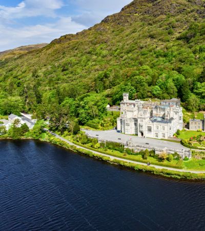 Manor House on lakeshore with hills