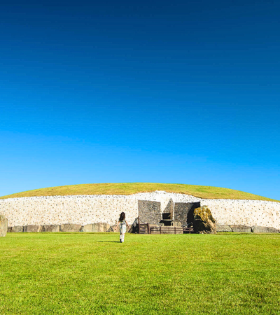 Woman walking towards entrance to Newgrange